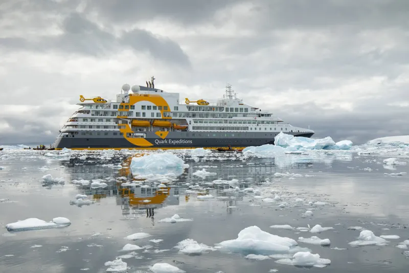 The expedition ship Ultramarine of Quark Expeditions with two helicopters on deck among icebergs in Antarctica